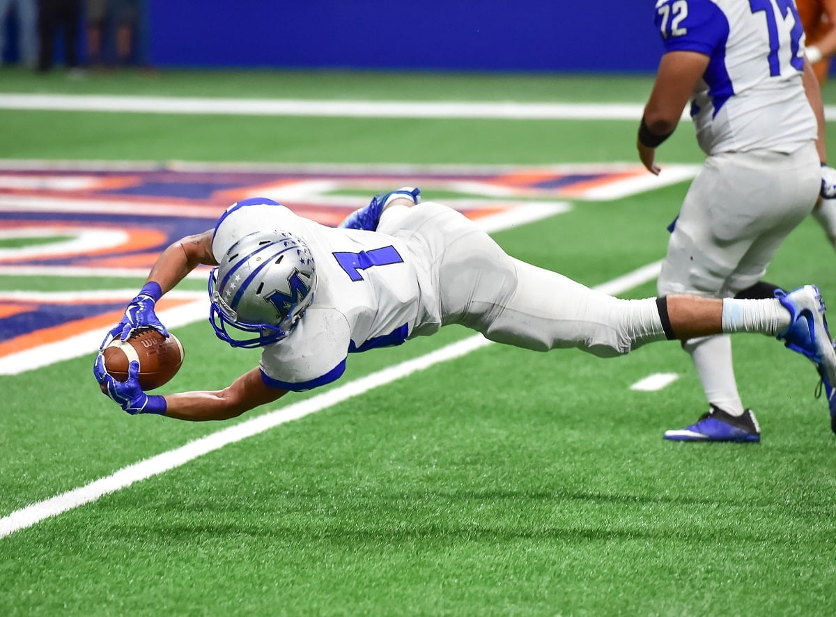 nfl football today - player diving for a ball from a side view